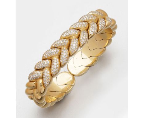 Gelbgold, gest. 750. Breite Bandform aus stilisierten geflochtenen Gliedern, schauseitig besetzt mit Brillanten von zus. ca. 