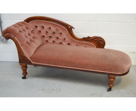 A Victorian walnut pink-upholstered button-back chaise longue, raised on castors, width approx 180cm.