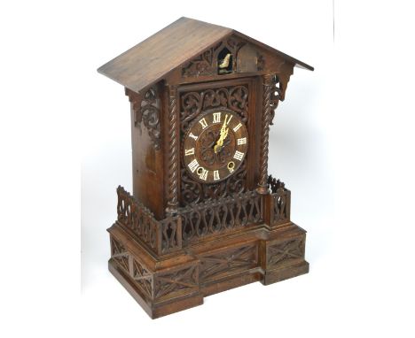 A large Black Forest carved cuckoo clock, the dial set with Roman numerals, height 50 x 35cm.   CONDITION REPORT  Evidence of
