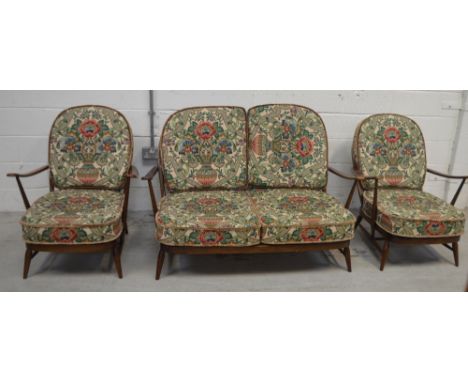 A retro Ercol three-piece stick-back suite comprising sofa, width approx 130cm and a pair of low armchairs (3).