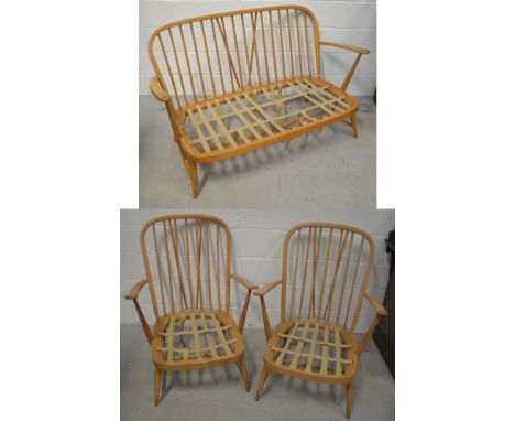 A retro Ercol stick-back three-piece suite comprising two-seater sofa, width approx 115cm and two low armchairs (3).