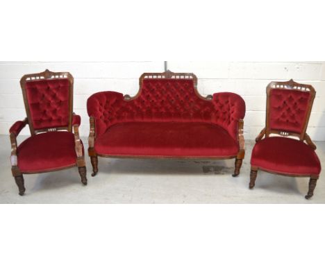 A Victorian walnut and inlaid three-piece suite comprising cerise upholstered button-back sofa width 160cm, matching button-b