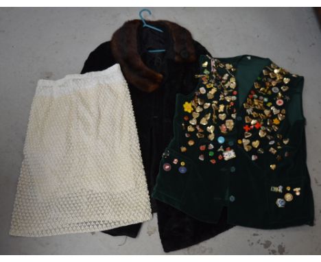 A green suede waistcoat adorned with various badges, a vintage ladies' Astrakhan coat with fur collar and a vintage cream bea