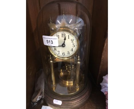 Brass revolving pendulum clock under a ghlass dome  |Pendulum detached. Brass base tarnished