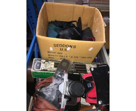 A box of cameras and accessories including a tripod, camera cases and lenses.