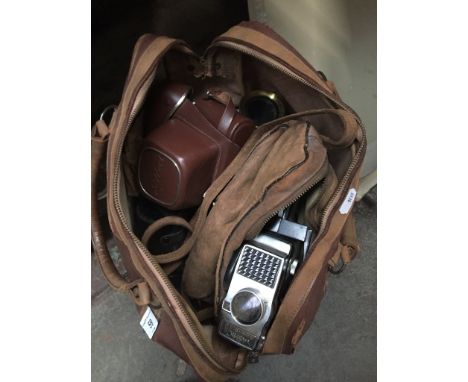 A vintage holdall containing various cameras, accessories, etc to include Yashica Super-8 10 movie camera, Weston Master 3 un