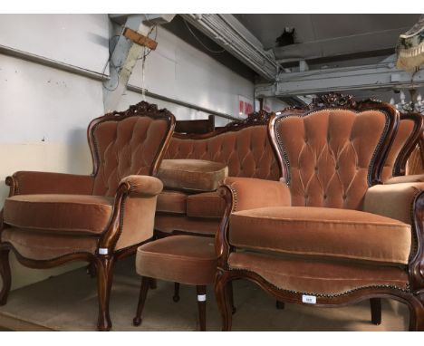 A carved wood sofa, two armchairs and a footstool.  
