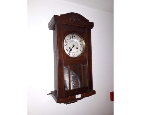 An early 20th century mahogany cased wall clock with pendulum and key.  