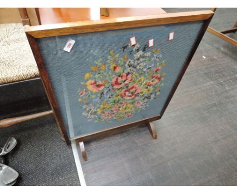 An oak framed woolwork firescreen