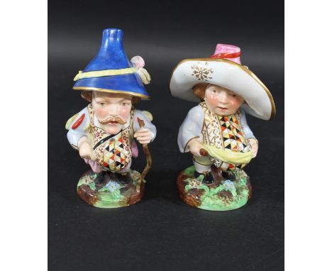 PAIR OF DERBY STYLE MANSION HOUSE DWARVES a pair of porcelain figures, one holding a walking stick with a blue painted hat, t