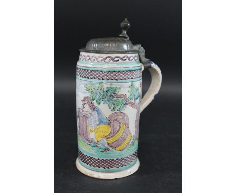 CONTINENTAL FAIENCE POTTERY TANKARD - BEARS DATE '1723' painted with a figure seated on a barrel and resting his hands on a t