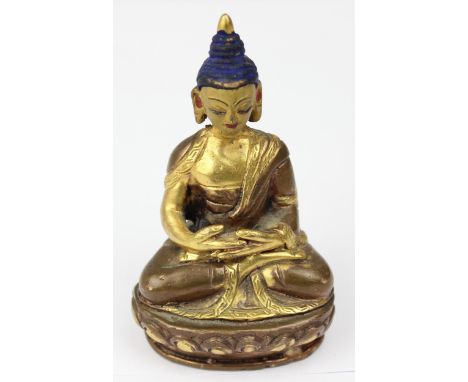 A small Buddhist deity seated on a lotus throne, bronze-like copper alloy with good quality gilt and painted details, likely 