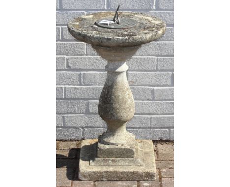 A weathered stone sundial with baluster support, 45cm in diameter x 80cm tall