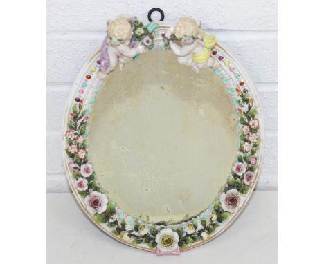 An antique Sitzendorf mirror decorated with cherubs and floral sprigs, 34cm tall