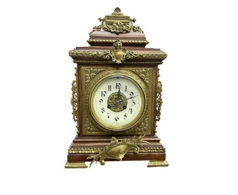 French - Early 20th century 8-day mantle clock in an oak case with pierced brass frets to the sides and raised on bracket fee