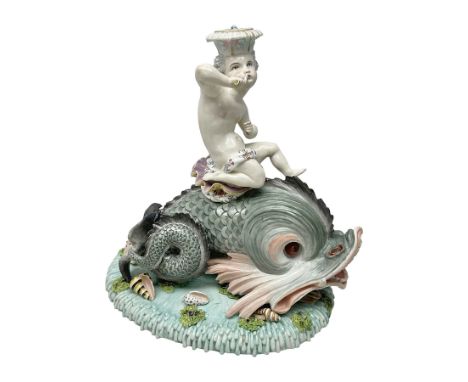 Early 20th century continental centrepiece, modelled as a putti riding a dolphin, upon a blue base decorated in relief with s