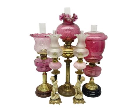 Victorian cast brass oil lamp, with fluted pink glass shade, together with two smaller brass oil lamps with pink shades and r