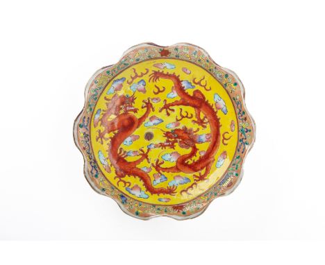A YELLOW GROUND 'DRAGONS CHASING A PEARL' OFFERING DISH The dish with an undulating scalloped edge and waisted foot, the cent