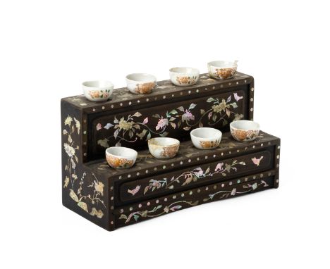 A MOTHER OF PEARL INLAID STAND WITH EIGHT SMALL TEA BOWLS
The two tier stand decorated with flowers and trailing foliage
(One