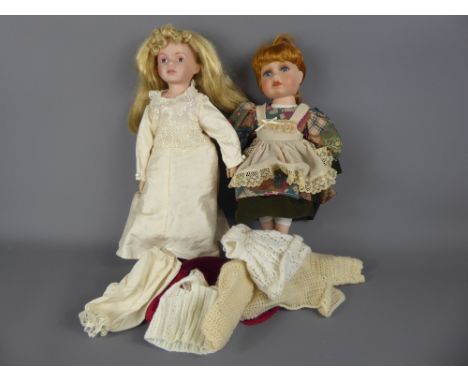 Two Bisque-Headed Dolls, with bisque hands and legs, approx 40 cms with a small quantity of clothes.