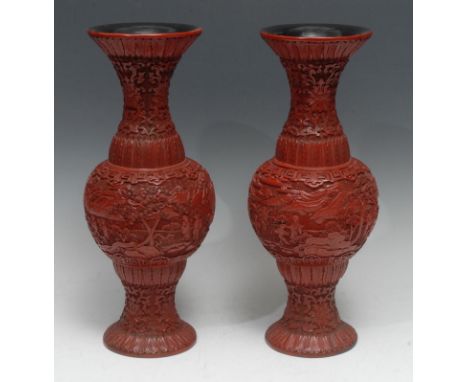 A pair of Chinese red cinnabar lacquer baluster vases, well carved in high relief with figures in a monumental landscape, the