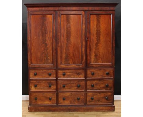 An early Victorian mahogany wardrobe, moulded outswept cornice above three panel doors, the left and centre each incorporatin