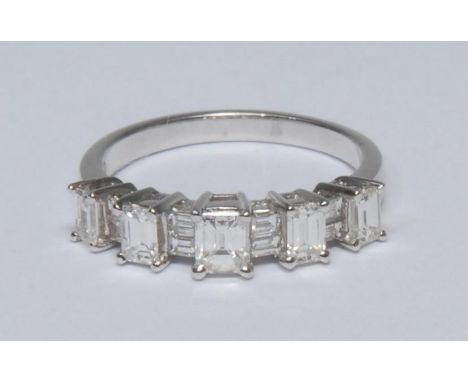 A contemporary design graduated step cut diamond ring, five graduated raised tower claws each inset with a single rectangular