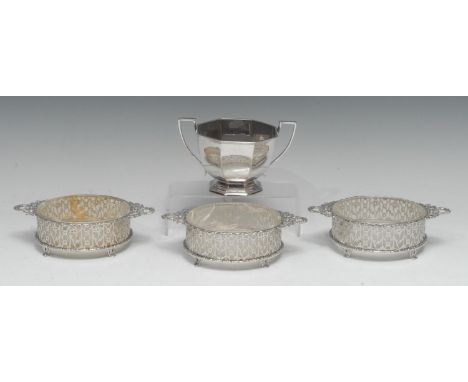 A set of three George V silver circular butter dishes, pierced borders, laurel wreath handles, 16cm wide, Wilson &amp; Gill, 