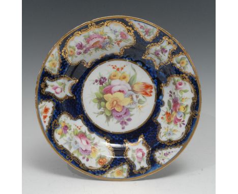 A Coalport circular soup plate, attributed to William Billinglsey, with panels of flowers on a scale blue ground, gilt border