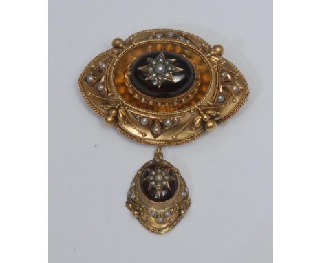 A Victorian garnet and seed pearl mourning brooch, central oval garnet cabochon with seed pearl star center, within shaped ov