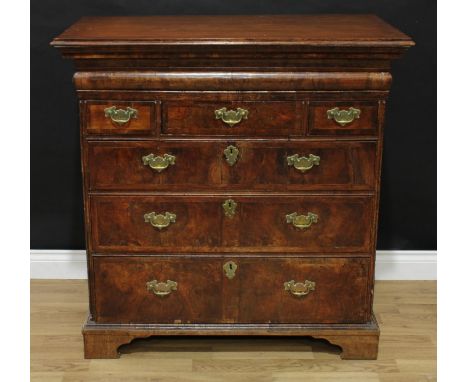 A George I walnut chest, oversailing rectangular top above a cushion moulded drawer, three short and three long graduated dra