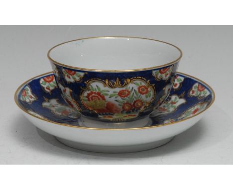 A Barr Worcester tea bowl and saucer, painted in the Kakiemon taste on a scale blue ground, picked out in gilt, the saucer 14