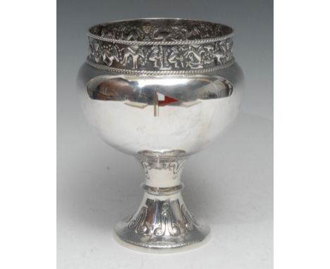 A George V silver and enamel pedestal bowl, after an ancient model, the tall rim chased with a band of stylised figures, anim