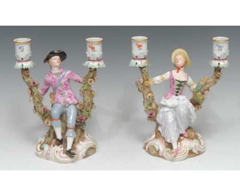 A pair of Meissen figural two-light candelabra, modelled as a gallant and his sweetheart, each dressed in the 18th century pa