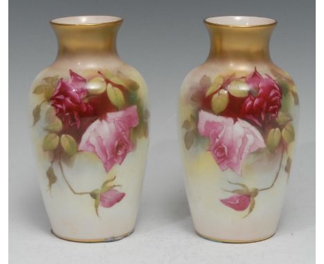 A pair of Royal Worcester vases, each painted with roses, on a blush ivory ground, gilt flared rims, model no. 2226, puce cro