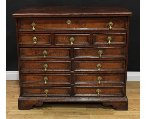 A 17th century oak chest, oversailing rectangular top with moulded edge above one long, three small and four rows of two shor