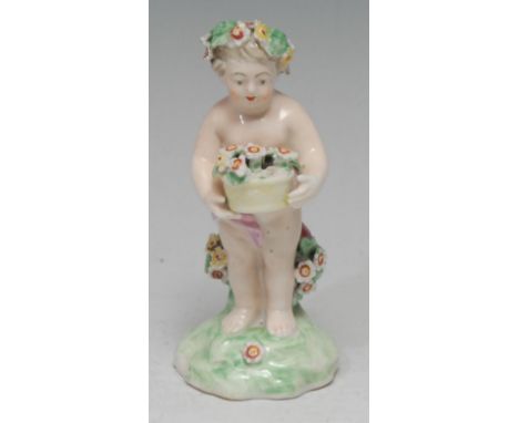 A Derby Patch Mark figure, of a Putti, standing scantilly draped with floral chaplet, holding a basket of flowers, 11cm high,