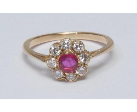 A diamond and ruby cluster ring, central round cut ruby surrounded by a collar of eight brilliant cut diamonds, total estimat