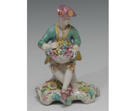 A Derby Patch Mark figure, Allegorical of  Autumn,  seated on a tree stump, he wearing an upturned hat, holding a  basket of 