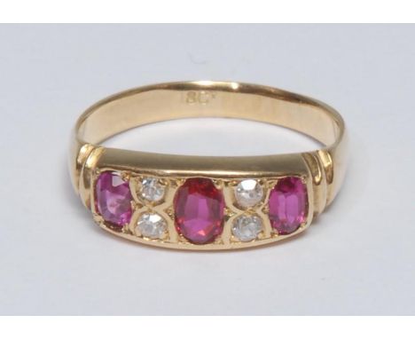 A ruby and diamond ring, inset with three oval cut red rubies, each divided by a pair of old brilliant cut diamonds, total es