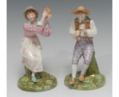A pair of Royal Worcester Hadley figures of musicians, seated on tree stumps, he with a flute, she with a tambourine, decorat