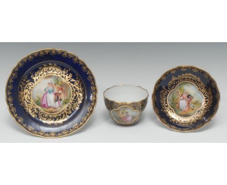 A German porcelain cabinet ogee-shaped teacup, saucer, and tea plate, painted in the manner of Sèvres with Watteauesque lover