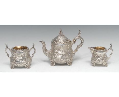 A Victorian silver composed three piece pear shaped Teniers bachelor's tea service, comprising teapot, milk jug and sugar bas