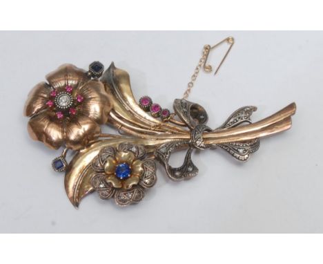 A mid 20th century multi stone diamond, ruby and sapphire floral brooch, multi layered body as a bunch of two flowers, encrus