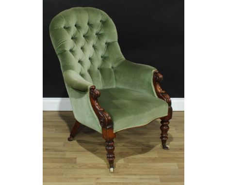 An early Victorian mahogany drawing room chair, deep button stuffed over upholstery, lotus scroll carved arms, turned legs, c