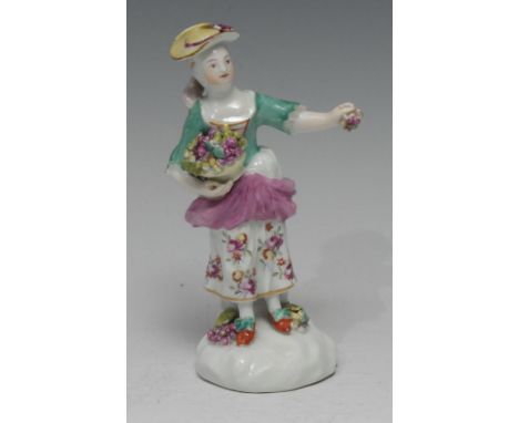 An early  Derby Patch Mark figure, Allegorical of Autumn, she stands holding a basket of grapes and holding a bunch of grapes