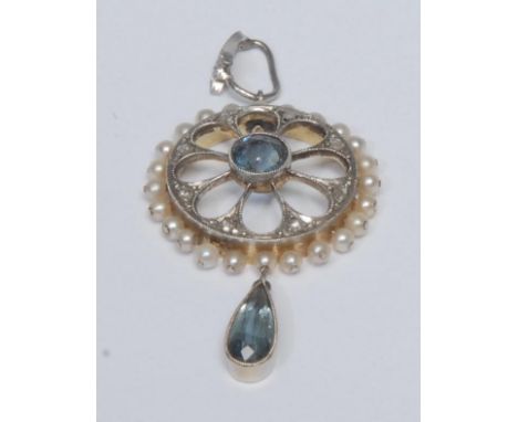A diamond, seed pearl and pale blue stone possibly aquamarine pendant, open cast mount with central circular pale blue stone,