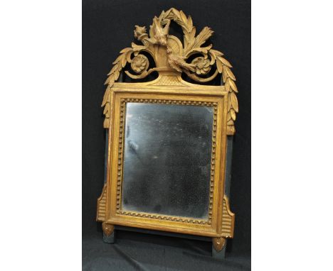 A 19th century giltwood, gesso and ebonised easel mirror, lofty cresting with lovebirds, trophy flowerheads and stiff leaves,