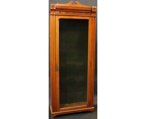 A Victorian Aesthetic period oak library bookcase, shaped cresting above a deep frieze carved with stylised lotus bosses, ful