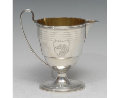 A George III silver oval pedestal cream jug, moulded rim above a deep band of wrigglework, bright-cut unusually engraved with